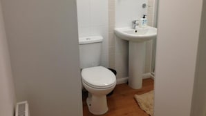 Un baño pequeño con inodoro, lavabo y espejo.