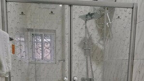 Un bagno con cabina doccia in vetro, un water e un lavandino.