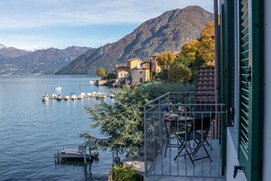 Une propriété au bord du lac, dotée d’une terrasse, de bateaux amarrés et avec des montagnes en toile de fond.