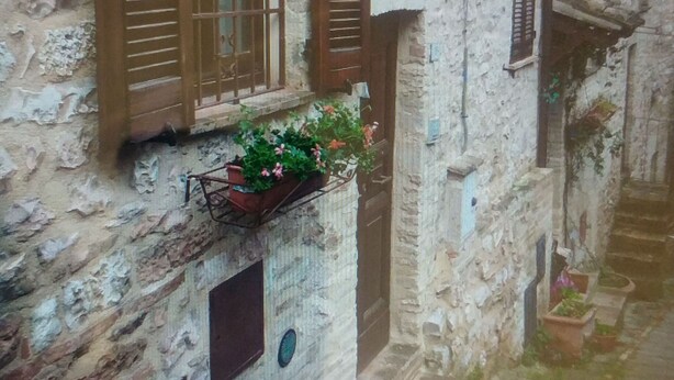 A narrow street with stone buildings, wooden shutters, and a small flower box on the wall. - Casa Sara Holiday Home (Spello)