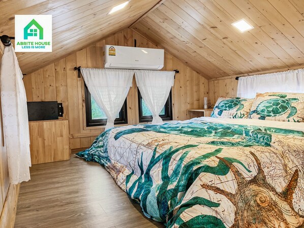 A cozy wooden cabin bedroom with a bed, two windows with curtains, an air conditioning unit, and a small bedside table. - Tiny House on Koh Lanta Only 2 Minutes Walk to the Beach (Ko Lanta)