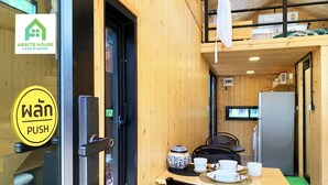 Interior de madera con una mesa dispuesta para comer, un refrigerador y una cama con literas.