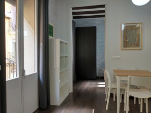 A room with a wooden dining table and chairs, a white cabinet, and a dark door. - Lovely Flat In Barceloneta Near Sea (Barcelona)