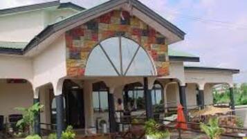 A building with a distinctive arched entrance and a covered patio area with outdoor seating.