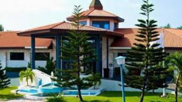 A building with a central pavilion, a swimming pool, and surrounding greenery. - Luxurious Sunset Hotel in Kumasi (Kumasi)