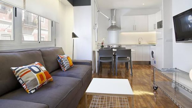 A modern apartment with a living room, kitchen, and dining area.