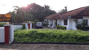Un bâtiment avec un toit rouge, des murs blancs et une enseigne sur laquelle on peut lire « Hôtel ».
