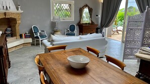 Una habitación acogedora con una mesa de comedor de madera, un sofá blanco y una chimenea.