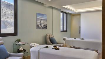 Relax in a serene spa room with two treatment beds, a massage chair, and a peaceful mountain view.