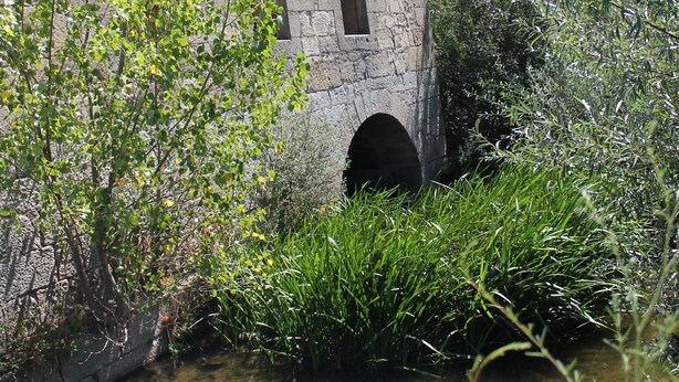 Un edificio de piedra con ventanas de arco y una entrada pequeña.
