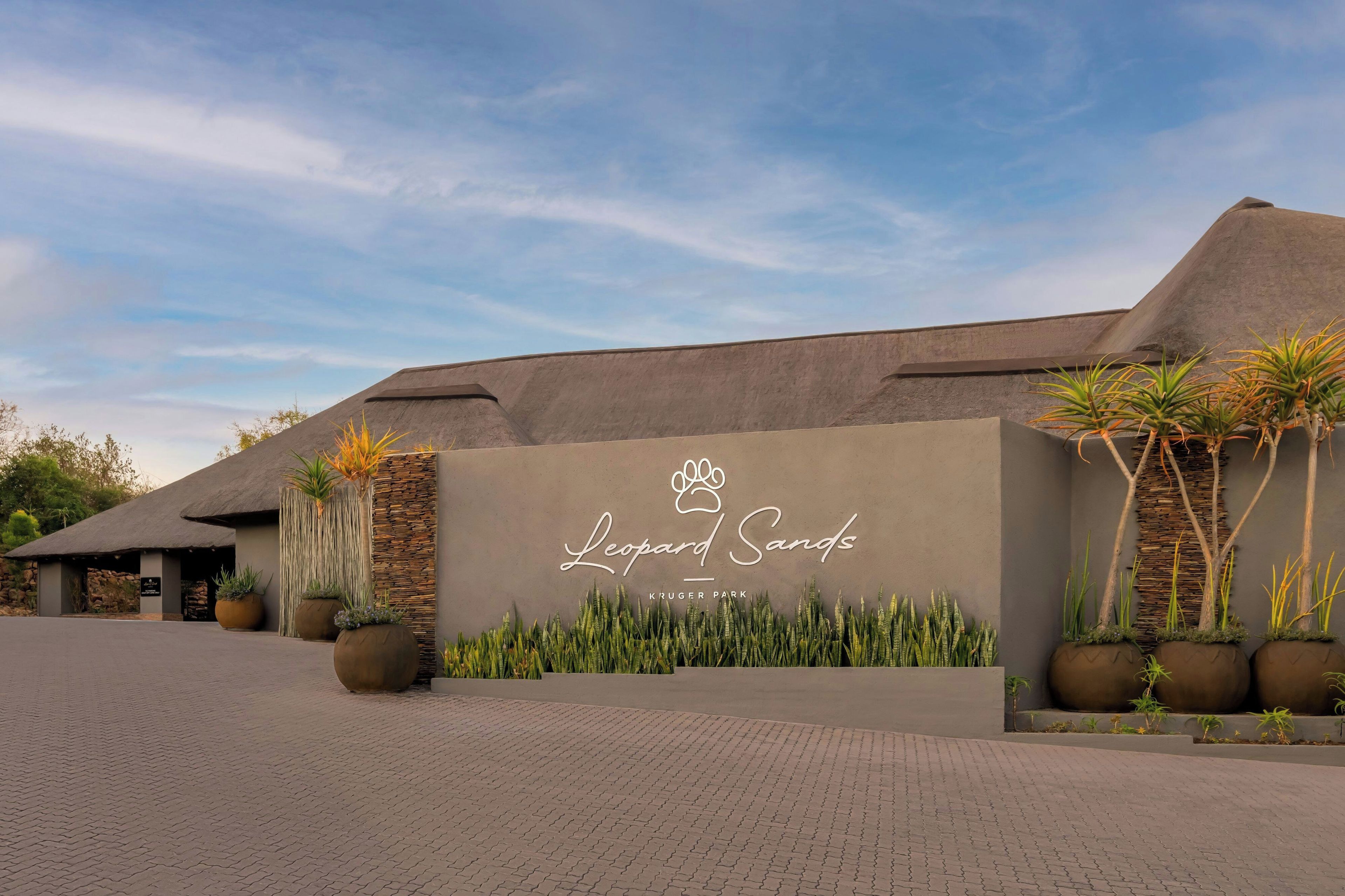 A building with a sign reading 'Leopard Sands' and 'Kruger Park' indicating a safari lodge or park entrance.