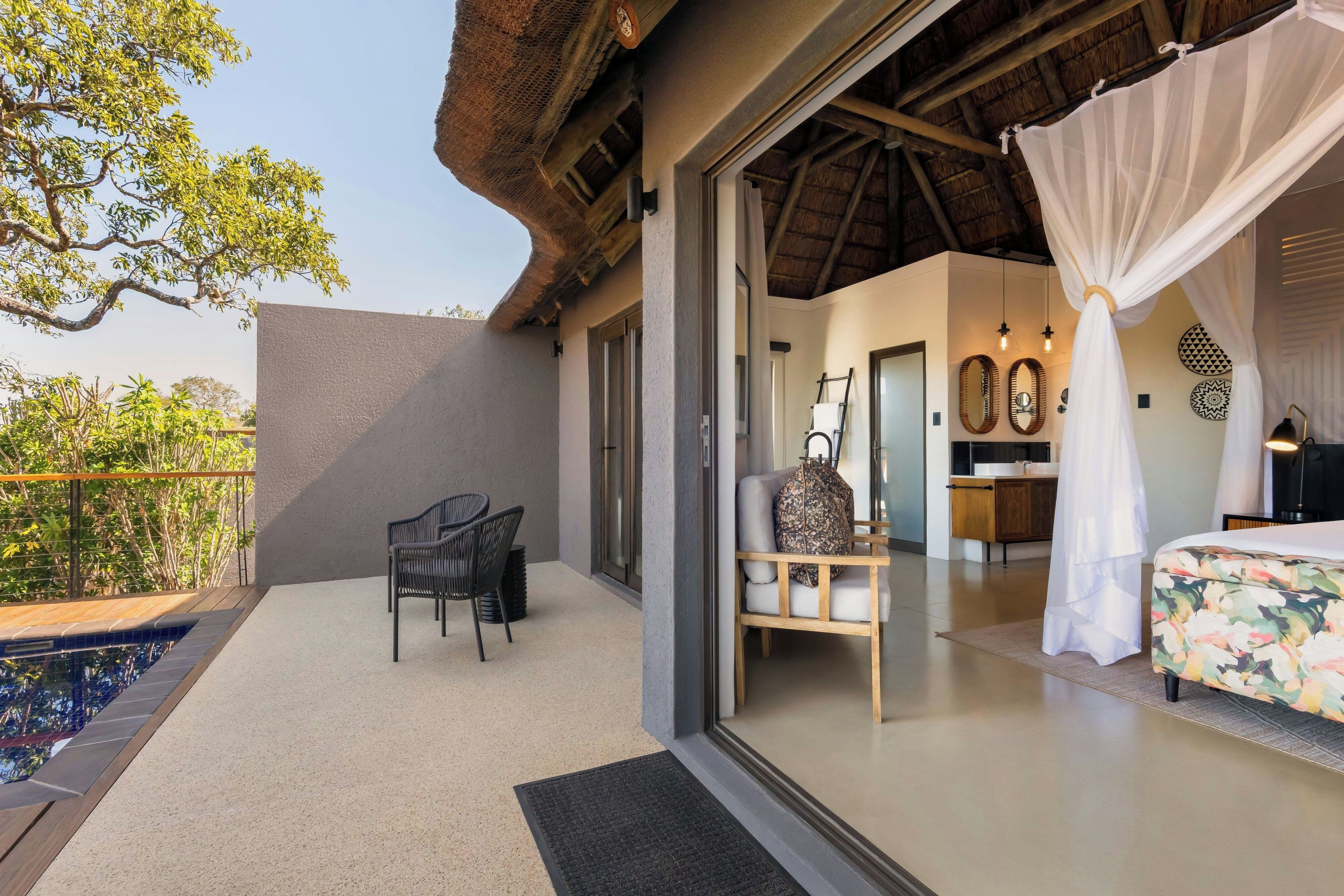 Una habitación con cama, una silla, una mesa y una ventana.