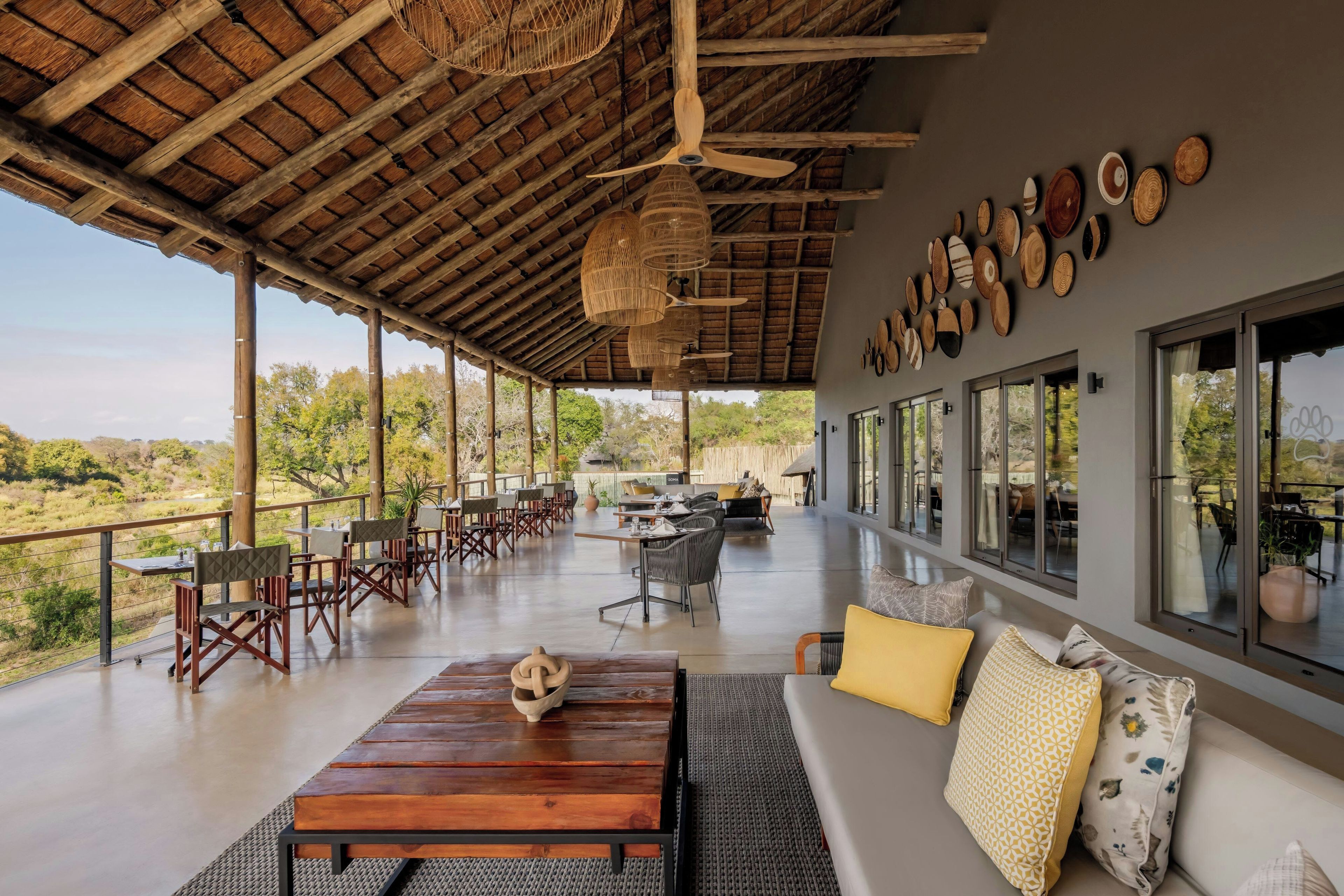 Un salón tipo loft con una mesa de madera, asientos y vistas al exterior.