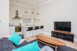 A modern living room with a sofa, coffee table, and a TV.