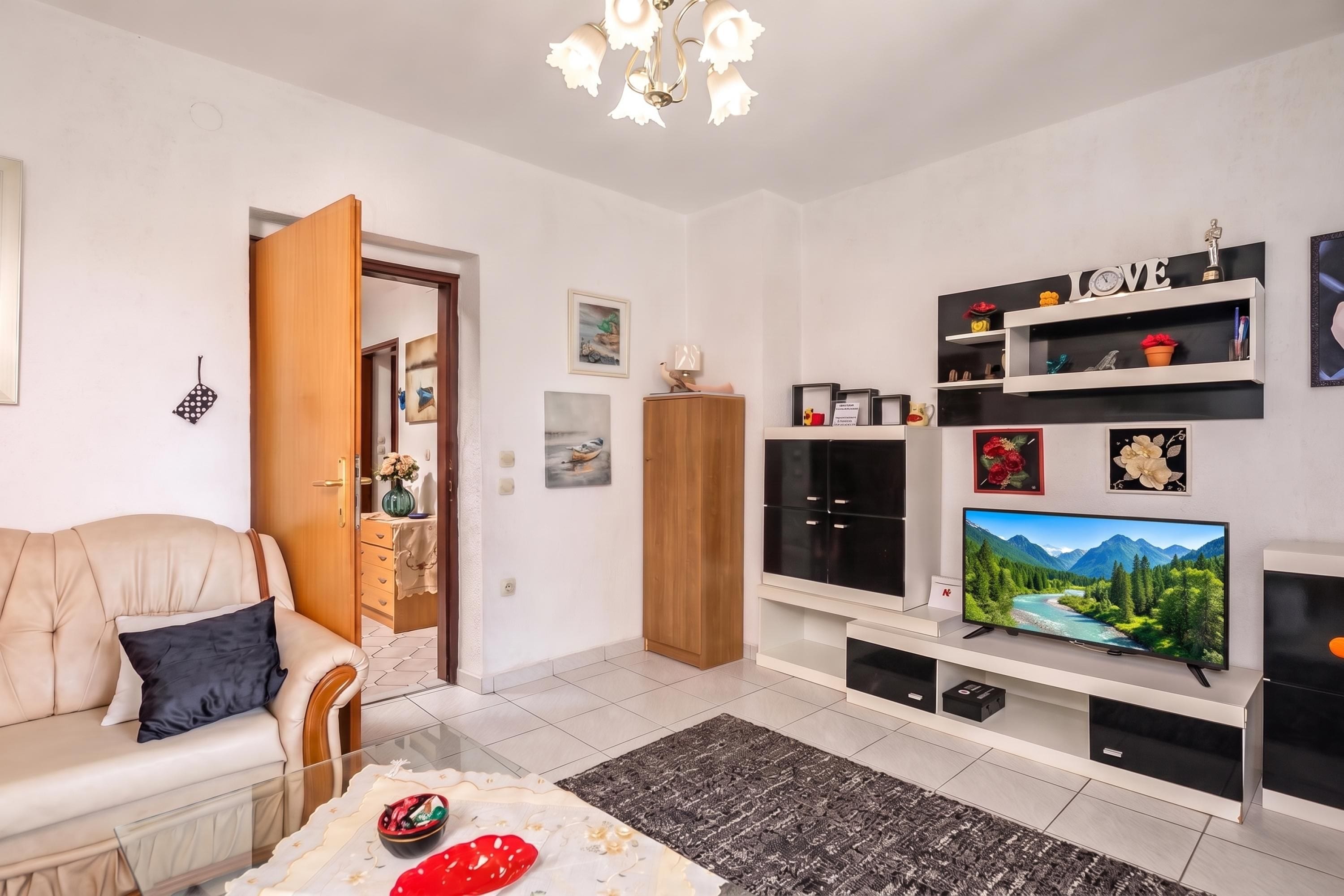 Un salon moderne avec un canapé, un téléviseur et un meuble.