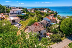 Zona residencial costera con casas, una piscina y vistas despejadas al mar.