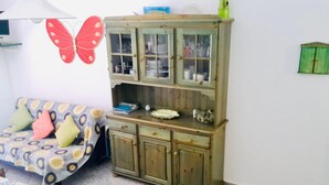 A room with a bed, a wooden cabinet with glass doors, and a butterfly decoration on the wall. - Quadrilocale Gallura (San Teodoro)