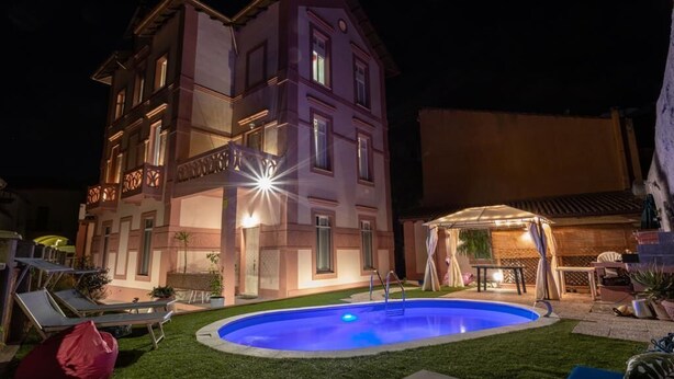 A multi-story building with a swimming pool, outdoor seating, and a covered patio area. - Dependence 2 Fronte Piscina in Centro Storico (Oristano)