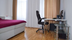 A bedroom with a bed, a desk, and a chair. - Modern apartment in Vienna near Danube (Vienna)
