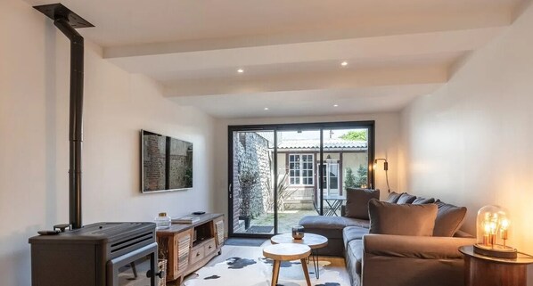 Un salon moderne avec un canapé, une table basse et une cheminée.