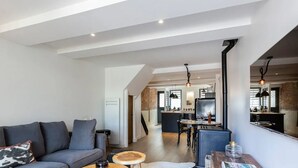 Un salon moderne comprenant un canapé, une table basse et un coin repas avec une table et des chaises.