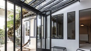 A modern interior with large glass doors leading to a patio area.