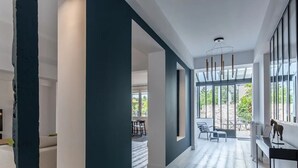 A modern interior with a large TV, a dining area, and a view of the outdoors.