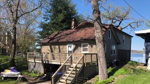 A two-story house with a deck and stairs leading to a covered porch.