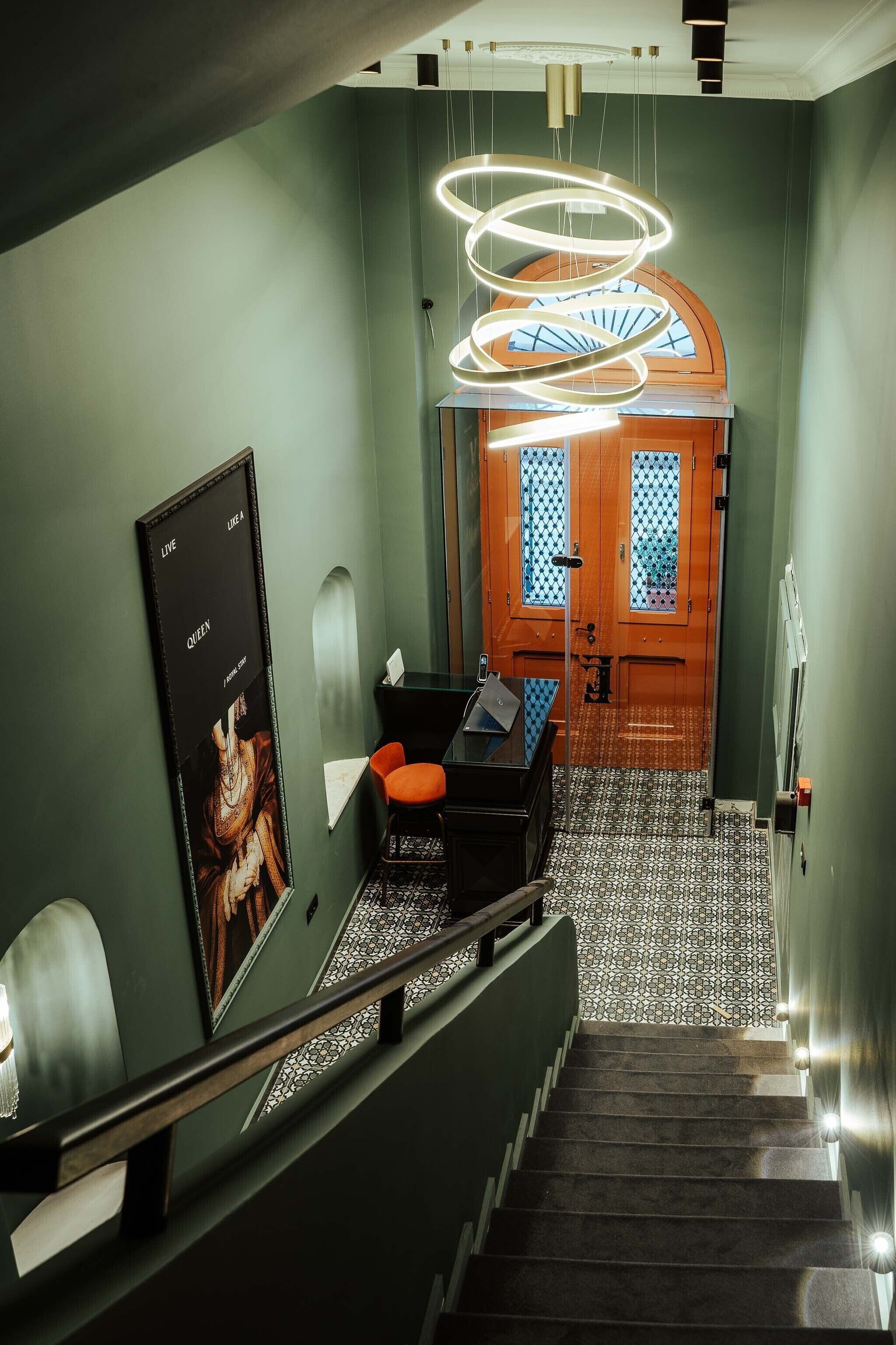 A staircase with a handrail, a poster on the wall, and a door with a window.