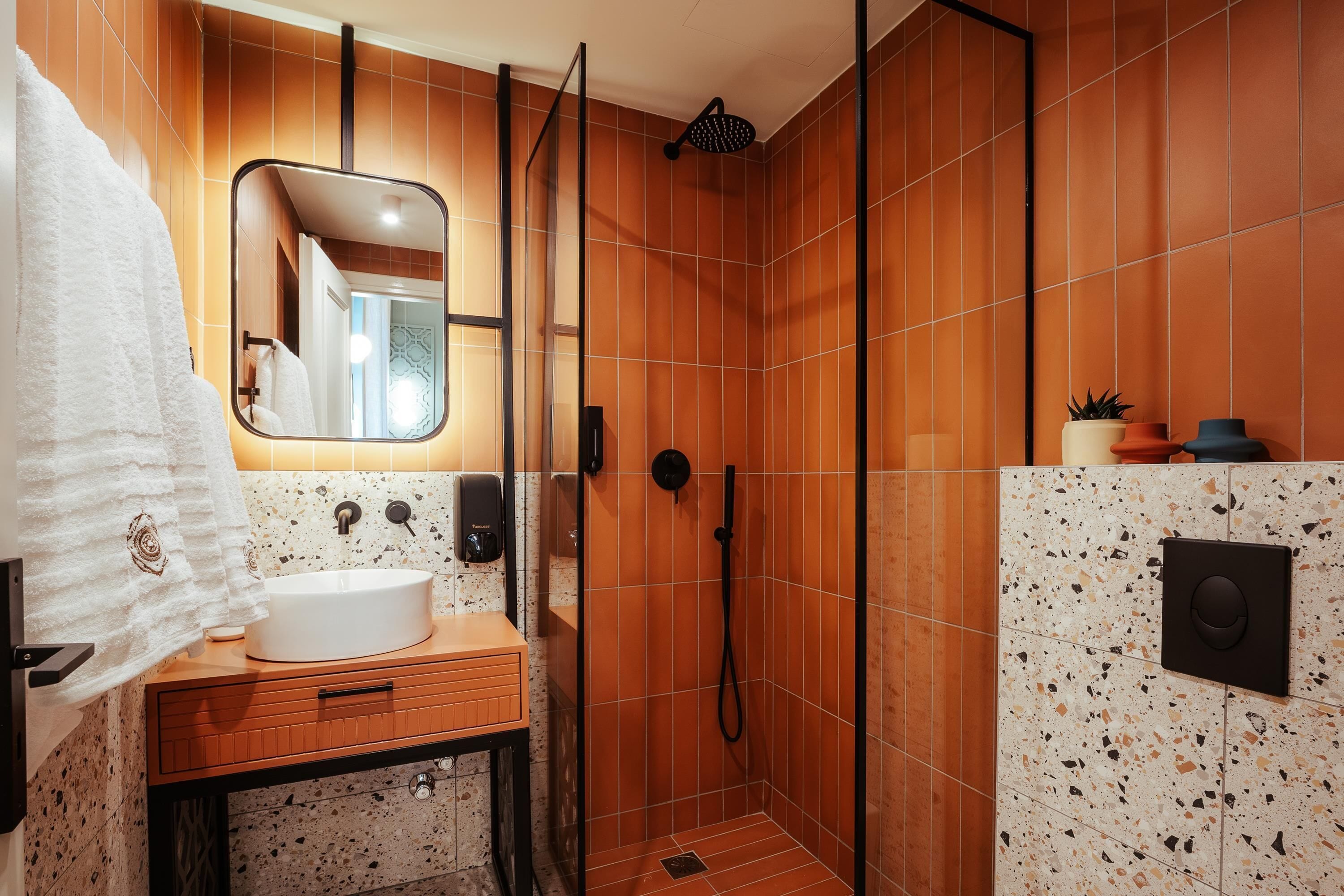 Un baño moderno con ducha, lavabo y espejo.
