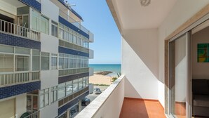 Ein Balkon mit Blick auf Strand und Meer.