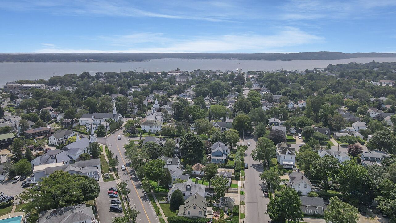 Un quartier résidentiel avec des maisons, des rues et une étendue d’eau en arrière-plan.