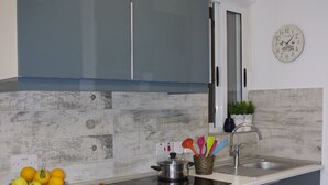 Une cuisine moderne avec des armoires bleues, un four en acier inoxydable et un plan de travail blanc.