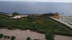 Une vue sur la côte avec un belvédère, des zones de sable et une promenade dallée.