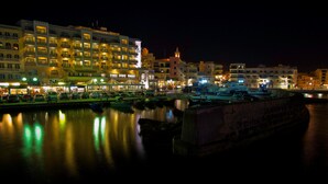 Un hôtel situé au bord de l’eau, doté de nombreux balcons, d’une cour intérieure et offrant une vue sur le port de plaisance.