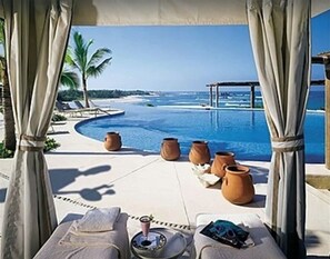 A poolside lounge with a view of the ocean, lounge chairs, and terracotta pots. - XMAS&NYE 25 Dates | Views | Four Seasons Privileges | Penthouse | Plunge Pool (Bahía de Banderas)