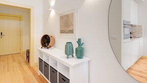 Une cuisine moderne avec des meubles blancs, un pare-feu en marbre et un four encastré.