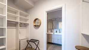 A walk-in closet with open shelving, a drying rack, and a mirror.