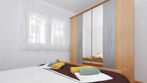 Ein Hotelzimmer mit Bett, Schrank und einem fenster mit Vorhängen.