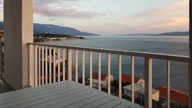 A balcony with a view of a calm sea and distant mountains. - Apartment Andela (Senj)