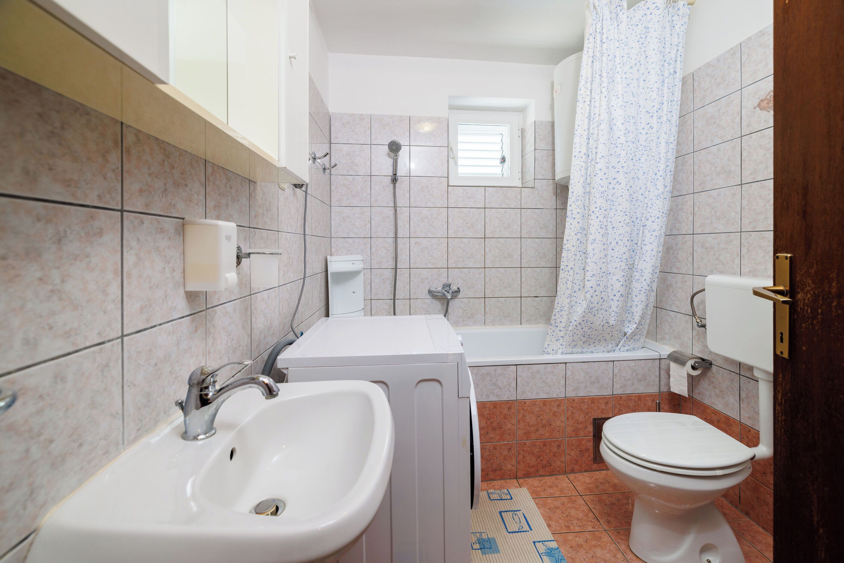 Une salle de bain avec un lavabo, des toilettes et une douche.