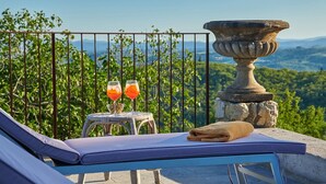 A balcony with a lounge chair, two glasses of orange juice, and a stone urn. - Montelodoli Capanna, Gaiole in Chianti, Siena and Chianti (Gaiole in Chianti)