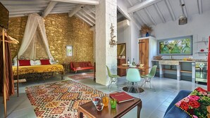 A spacious living area with a bed, sofa, dining table, and chairs. There is a kitchen area with a stove and sink. - Montelodoli Capanna, Gaiole in Chianti, Siena and Chianti (Gaiole in Chianti)