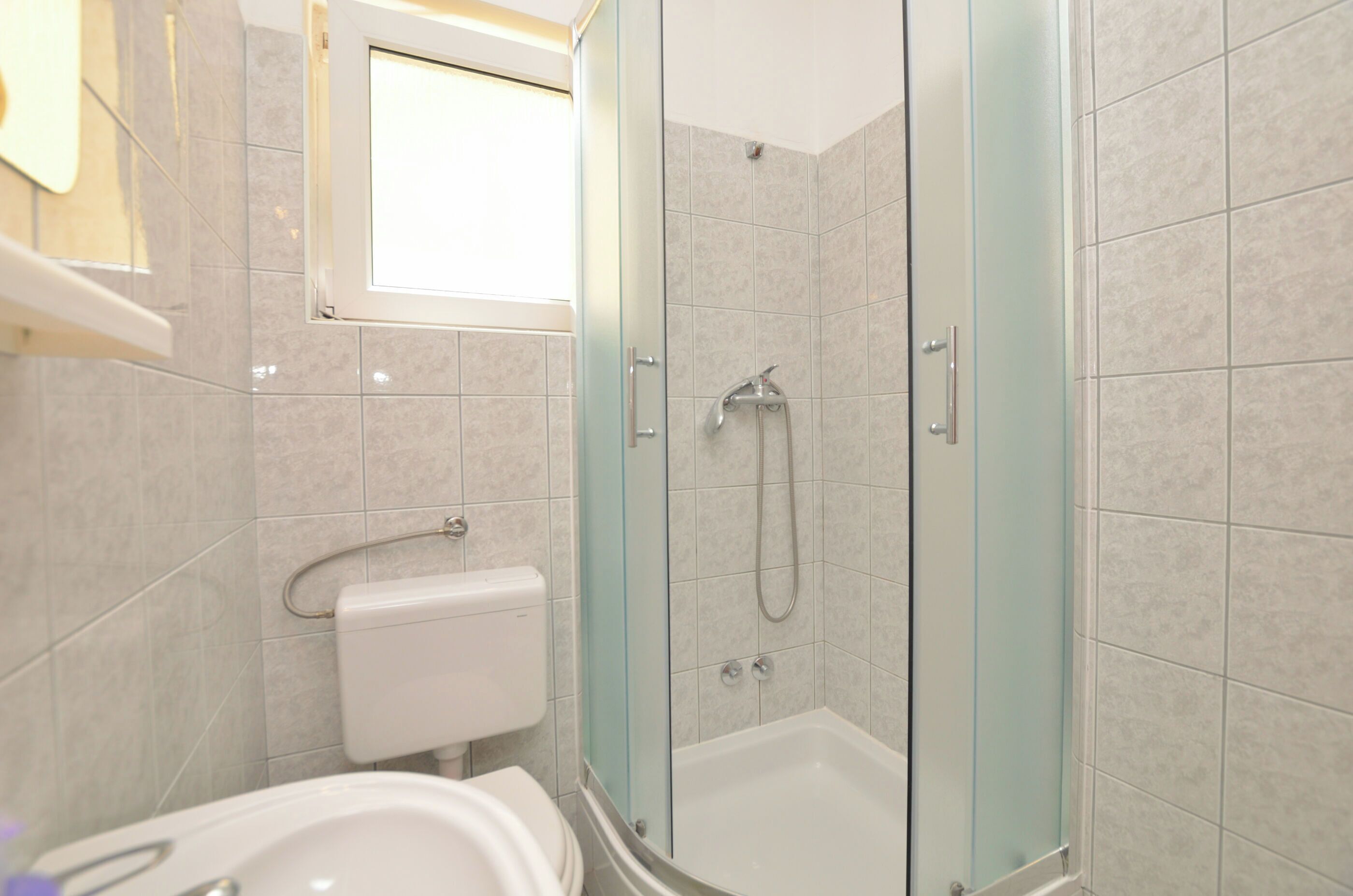 A bathroom with a glass-enclosed shower, a toilet, and a bathtub.