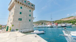 A historic stone building with multiple windows and a port with several boats docked. - Apartments Sea Star Ivana (Marina)