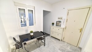 Een kamer met een eettafel, stoelen, een kast en een deur.