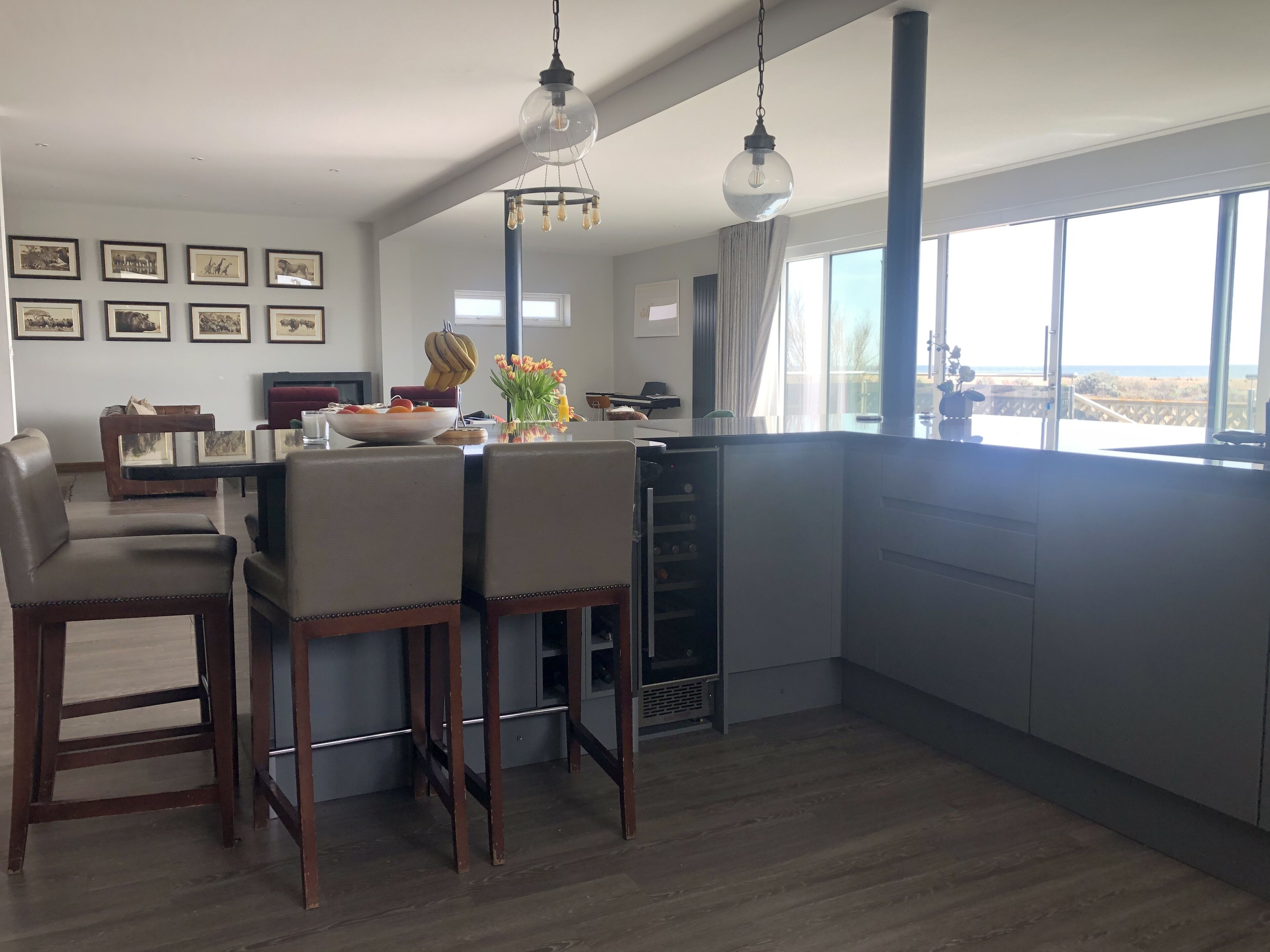 Una cocina moderna con comedor, ventanas amplias y obras de arte en las paredes.