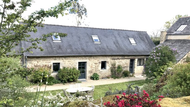 A stone house with a sloped roof, a small garden, and a stone pathway leading to the entrance. - Holiday home LES TIARELLES (Commana)