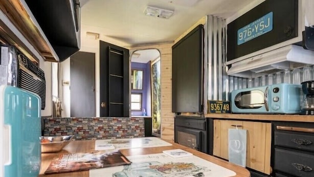 Cozinha compacta com micro-ondas, torradeira e uma placa de identificação na parede.