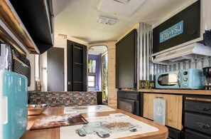 Une petite cuisine équipée d’un four à micro-ondes, d’un grille-pain et d’une plaque d’immatriculation accrochée au mur.